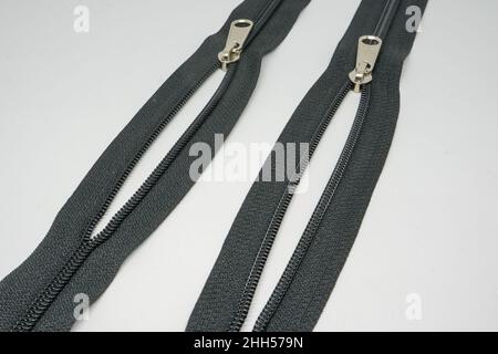 A zipper, zip, fly, or zip fastener, formerly known as a clasp locker, is a commonly used device for binding together two edges of fabric. Stock Photo