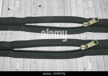 A zipper, zip, fly, or zip fastener, formerly known as a clasp locker, is a commonly used device for binding together two edges of fabric. Stock Photo