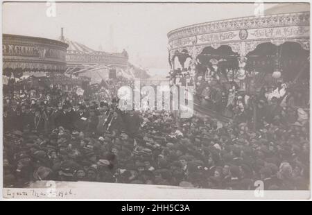 Kings Lynn Mart, Norfolk, 1906: crowds photographed among the fairground rides as civic dignitaries open the fair. The rides include 'Racing Cockerels' carousel and a 'Switchback Railway', signs in the crowd include ones for 'Lynn Football Star' and 'Hilton's Boots' Stock Photo