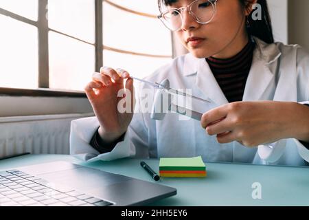 Young scientist examining wind turbine model in laboratory Stock Photo