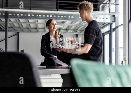 Businesswoman having discussing with trainee at industial hall Stock Photo