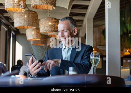 Smiling businessman using tablet PC in restaurant Stock Photo