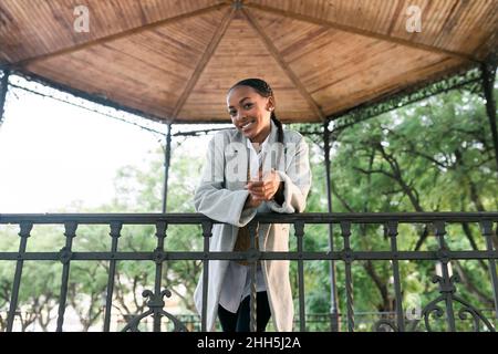 Smiling girl leaning on railing at gazebo Stock Photo