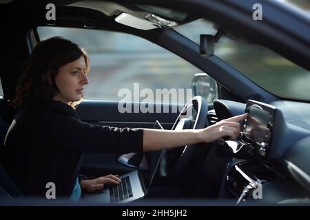 Businesswoman with laptop using navigation device in driverless car Stock Photo
