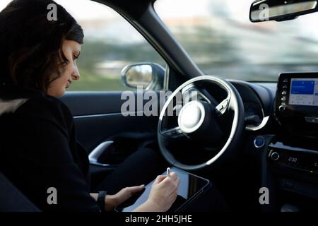 Businesswoman using tablet PC in driverless car Stock Photo