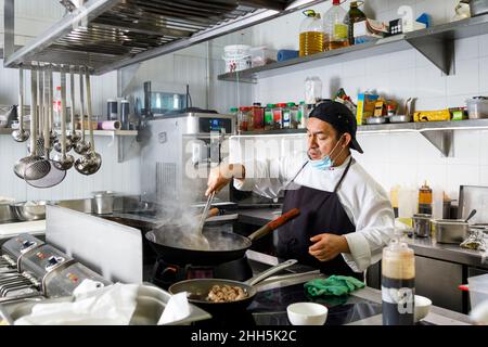 https://l450v.alamy.com/450v/2hh5k2c/chef-cooking-in-wok-at-restaurant-kitchen-2hh5k2c.jpg