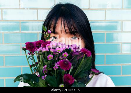 Young woman holding bouquet in front of face Stock Photo
