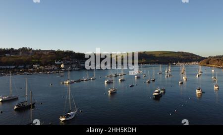 River Dart, Devon, England: Moored yachts and boats in evening sunlight on a winter's day - the town of Dartmouth is on the left of picture Stock Photo