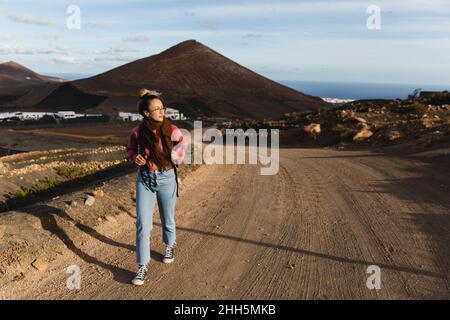 Young woman walking on dirt road Stock Photo