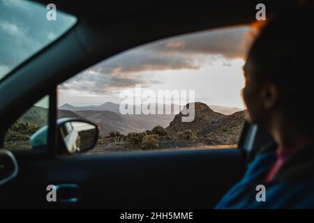 Woman in car looking at mountains Stock Photo