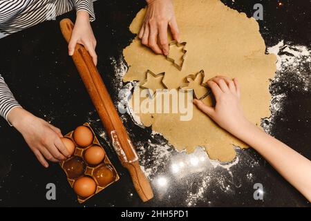 Family preparing cookies with cookie cutter on kitchen island Stock Photo