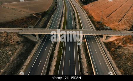 Empty bridge over highway passing by agricultural field in Lleida, Spain Stock Photo