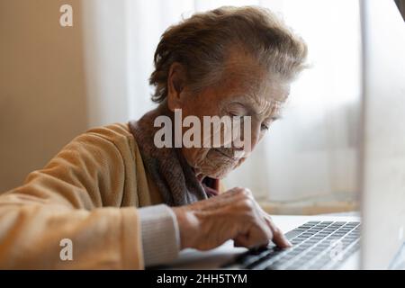 Elderly woman using laptop at home Stock Photo
