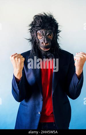 Euphoric man in a suit and with a gorilla mask. Stock Photo