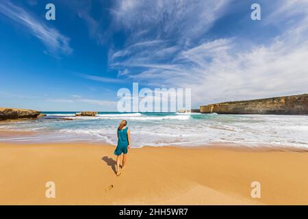 Female tourist walking alone along Sherbrook River Beach in Port Campbell National Park Stock Photo