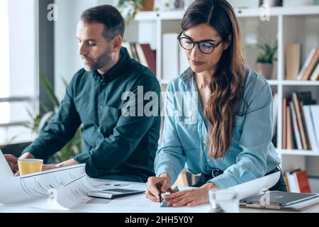 Architects working on desk in small office Stock Photo