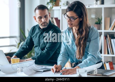 Architects discussing over blueprint in meeting at office Stock Photo