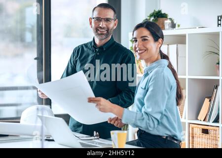 Smiling architects with floor plan in office Stock Photo