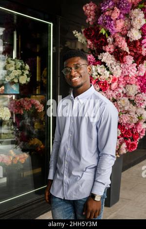 Smiling man standing outside flower shop Stock Photo