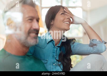 Smiling mature couple seen through glass at home Stock Photo