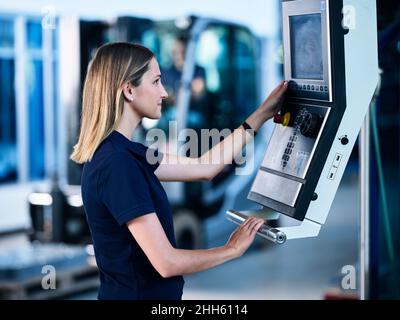 Engineer working on CNC machine in factory Stock Photo