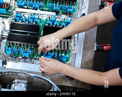 Technician connecting wires on circuit board Stock Photo