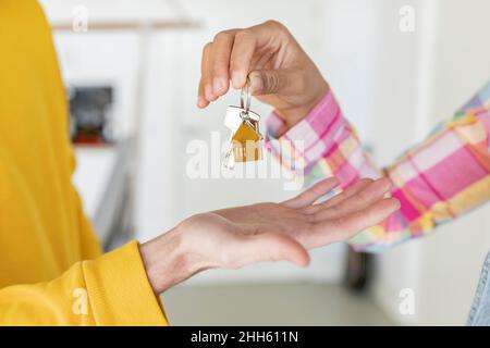 Woman giving house key to man Stock Photo