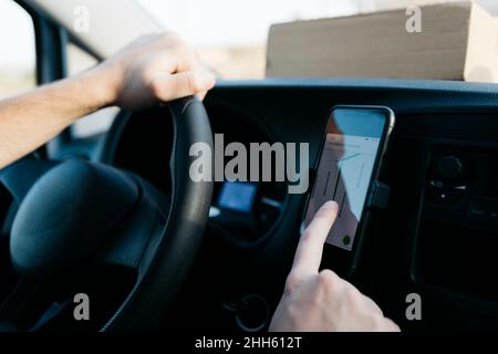 Man using GPS on smart phone while driving van Stock Photo