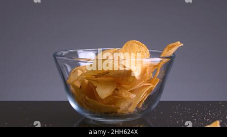 Chips falling on isolated background. Stock footage. Delicious chips fall and cause appetite. Harmful snacks in form of potato chips. Favorite junk fo Stock Photo