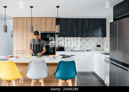 Man preparing food standing in modern kitchen at home Stock Photo