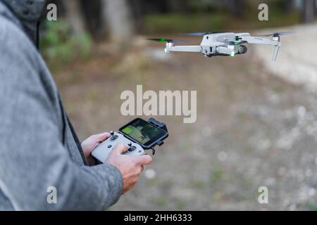 Pilot drone flying through radio controlled handset at park Stock Photo