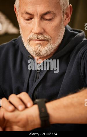Senior man using smart watch at home Stock Photo