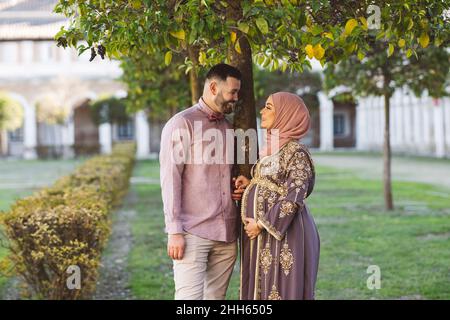 Smiling heterosexual couple talking by tree in park Stock Photo