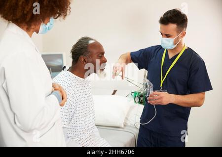 Nurse helping patient with oxygen mask at hospital Stock Photo