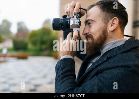 Young bearded man photographing through camera Stock Photo