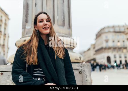 Beautiful young woman in front of column Stock Photo