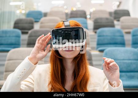 Working woman using virtual reality headset in convention center at office Stock Photo