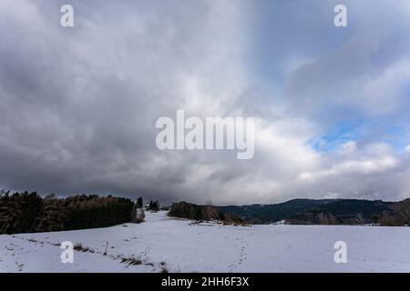 Horizon with dark dramatic sky and clouds in winter. Stormy Clouds Over Farm Field Stock Photo