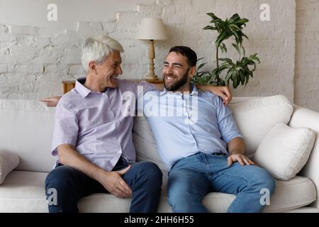 Happy elder father embracing smiling grownup son with love Stock Photo