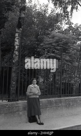 1950s, historical,a  lady standing by a railing below a sign for the Maison Natale De Jeanne d'Arc, at Domremy-la-Pucelle, France, where the french heroine, Joan of Arc, was born at the beginning of the 15th century. Stock Photo