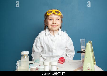 Cute student child in science class on blue background Stock Photo