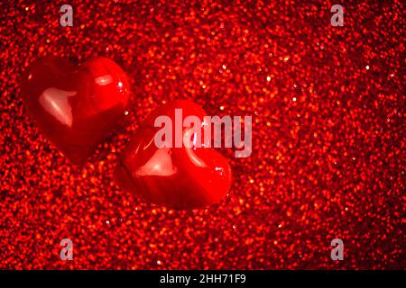 Valentines day background, two red hearts on red glitter background. Copy space Stock Photo