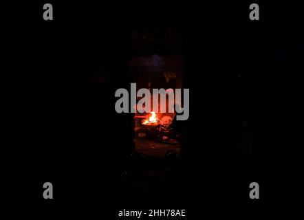 Gaza Strip, Palestine. 23rd January 2022. A Palestinian family sits around a fire to warm themselves inside their house during the cold weather at the Kha Yunis refugee camp in the southern Gaza Strip. Credit: Majority World CIC/Alamy Live News Stock Photo