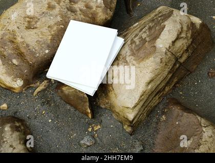 Blank book model placed on rocks in the sand, notebook mockup, mockup on nature background 01 Stock Photo