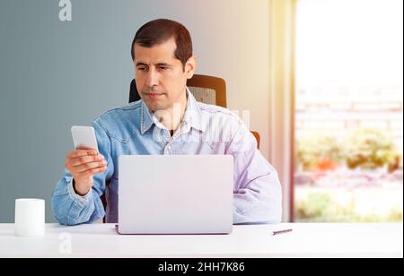 Cropped shot of a young businessman using a mobile phone at work Stock Photo