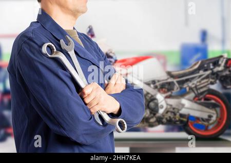 Close up of motorcycle mechanic standing with workshop background with copy space Stock Photo