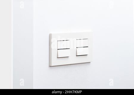 White light switch and faceplate on white wall Stock Photo