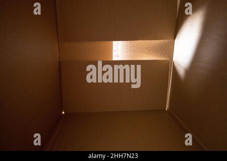 Brown cardboard box inside. Parcel concept. Light going iside. Stock Photo