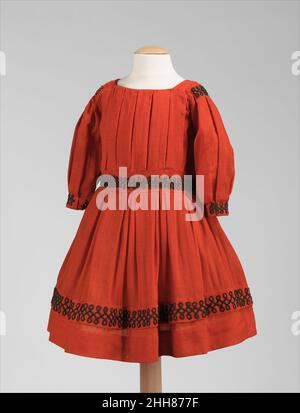 Dress ca. 1865 American This dress, worn by a boy or girl, is made complete with charming and stylish detailing. The sleeves are of a fashionable shape and the bodice is carefully pleated instead of simply being gathered. The alternating pleats in the skirt show the sophisticated level of construction. Finishing the piece, the soutache braid has been stylishly applied, which was also used in adult clothing in the 1860s.. Dress  159516 Stock Photo