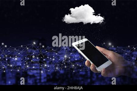 Cloud computing technology internet concept background. Hand hold white smartphone with digital hologram cloud sign on city dark blurred background. M Stock Photo
